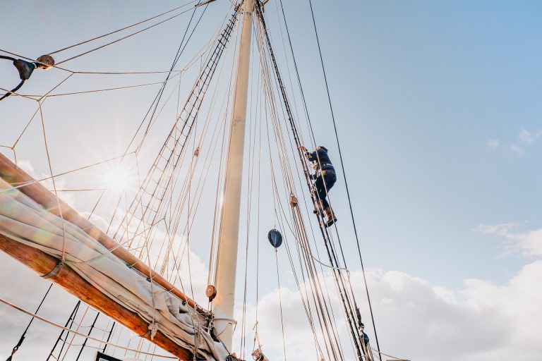 Blue Clipper guest climbing rigging on tall ship 768x512